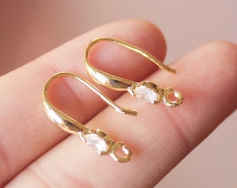 May include: Two gold-tone earring hooks with a clear crystal accent. The hooks are designed to be used for making earrings.