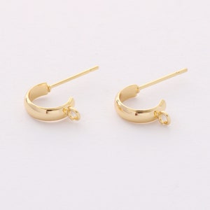 May include: A pair of gold-toned hoop earring findings with a jump ring attached to each hoop.