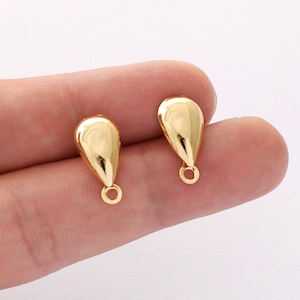May include: Two gold teardrop-shaped earring findings with a small loop at the bottom.