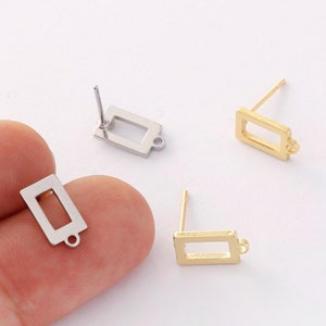 Puede incluir: Tres bases para pendientes, dos doradas y una plateada, con forma rectangular y un pequeño bucle en la parte inferior. Las bases para pendientes tienen un poste en la parte superior para sujetarlas a un pendiente.