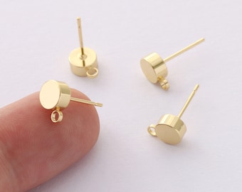 May include: Four gold-toned earring posts with a round top and a small loop on the side. The posts are designed for attaching earrings.