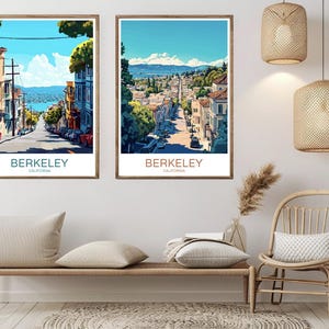 May include: Two framed art prints featuring street scenes of Berkeley, California. The artwork depicts a sunny day with buildings lining a road leading towards a body of water. The prints are in wooden frames and are displayed above a bench with pillows.