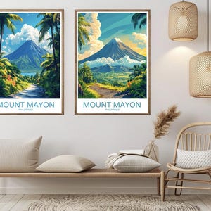 May include: Two colorful vintage travel posters featuring a scenic view of Mount Mayon in the Philippines. The posters are framed and hanging on a white wall.