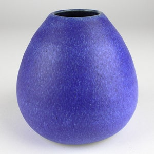 Könnte beinhalten: Eine blaue Keramikvase mit abgerundeter, tropfenförmiger Form. Die Vase hat eine gesprenkelte, strukturierte Oberfläche.