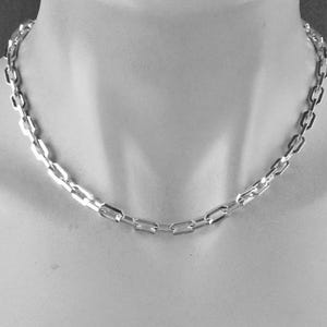May include: A silver chain necklace with a box chain design.