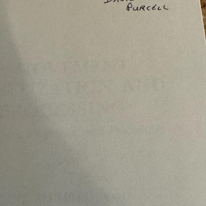 May include: A light gray paper with handwritten text. The text reads "David Purcell" with the word "David" in a larger font size. Above the name is the word "David" in a smaller font size.