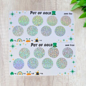 May include: Two white scratch-off cards with the text "POT OF GOLD" and a green leprechaun hat. Each card has holographic circles and the text "SAVE $60" and "SAVE $120". Shamrock and rainbow graphics are also present.