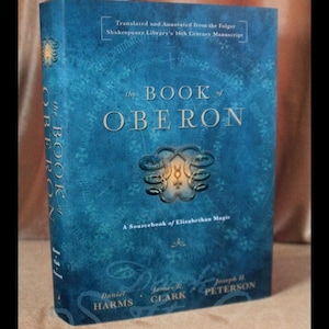 May include: A hardcover book titled "The Book of Oberon" with a blue cover. The title is in large, white letters. The book is a sourcebook of Elizabethan magic, translated and annotated from a 16th-century manuscript.