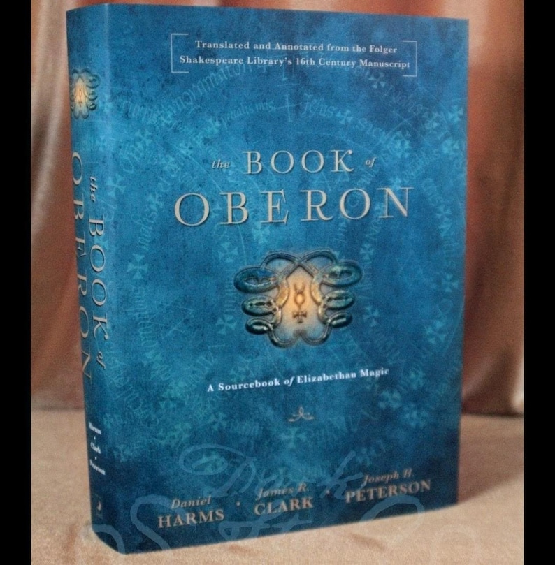 May include: A hardcover book titled "The Book of Oberon" with a blue cover. The title is in large, white letters. The book is a sourcebook of Elizabethan magic, translated and annotated from a 16th-century manuscript.