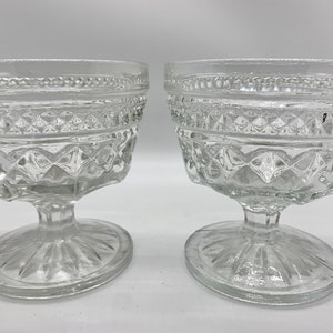 May include: Two clear glass dessert dishes with a diamond pattern and a pedestal base.