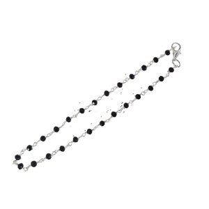 May include: A silver chain necklace with black beads. The necklace has a lobster clasp closure.