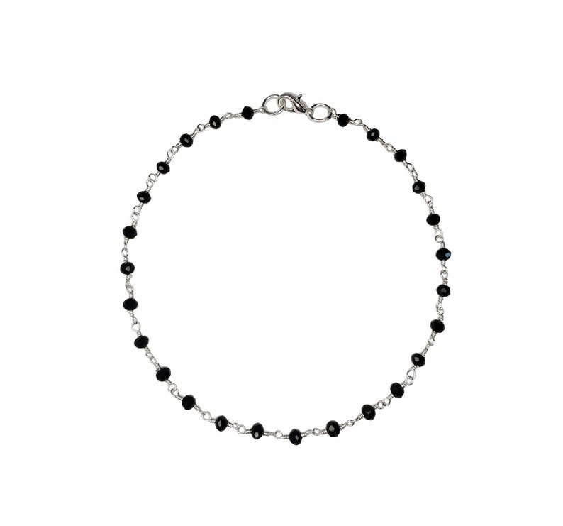 May include: A silver chain bracelet with black beads.