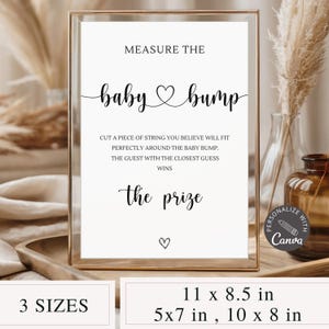 Può includere: Un cartello incorniciato con la scritta "Measure the baby bump" in corsivo nero. Il cartello include le istruzioni per un gioco baby shower ed è disponibile in tre misure: 27,9 x 21,6 cm, 12,7 x 17,8 cm e 25,4 x 20,3 cm. Il cartello è in una cornice dorata.