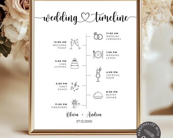 May include: A framed wedding timeline print with a gold frame. The black text reads "wedding timeline" and includes a schedule with illustrations for the ceremony, lunch, cake cutting, and fireworks. The names "Olivia + Andrea" and the date "27.12.2050" are also included.