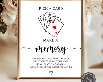 May include: A framed sign with the text "Pick a Card, Make a Memory." The sign features three playing cards with the Ace of Spades, Hearts, and Diamonds. The sign is in a gold frame and has a floral background.