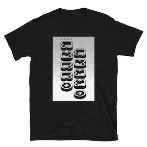 May include: Black t-shirt with a graphic design. The design features the text "Konami Command" in Japanese, along with a series of stylized, retro-style button icons in a vertical arrangement. The buttons are in black and white.