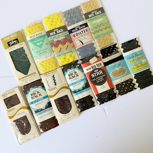 May include: A collection of twelve vintage rick rack trim packages in various colors including yellow, green, brown, black, blue, and gold. Each package features brand names like Talon, Wrights, Boiltex, and Star, with visible yardage and color labels.