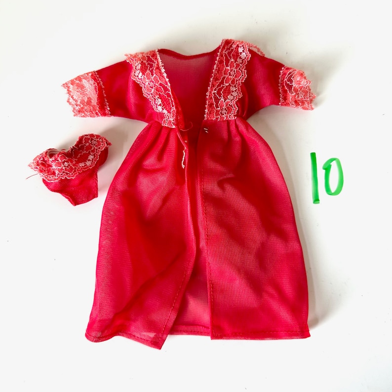 Op de afbeelding: Rode, doorschijnende badjas met kantversiering en bijpassende lingerie. De badjas heeft een V-hals en een striksluiting. De lingerie is een bh- en slipset.