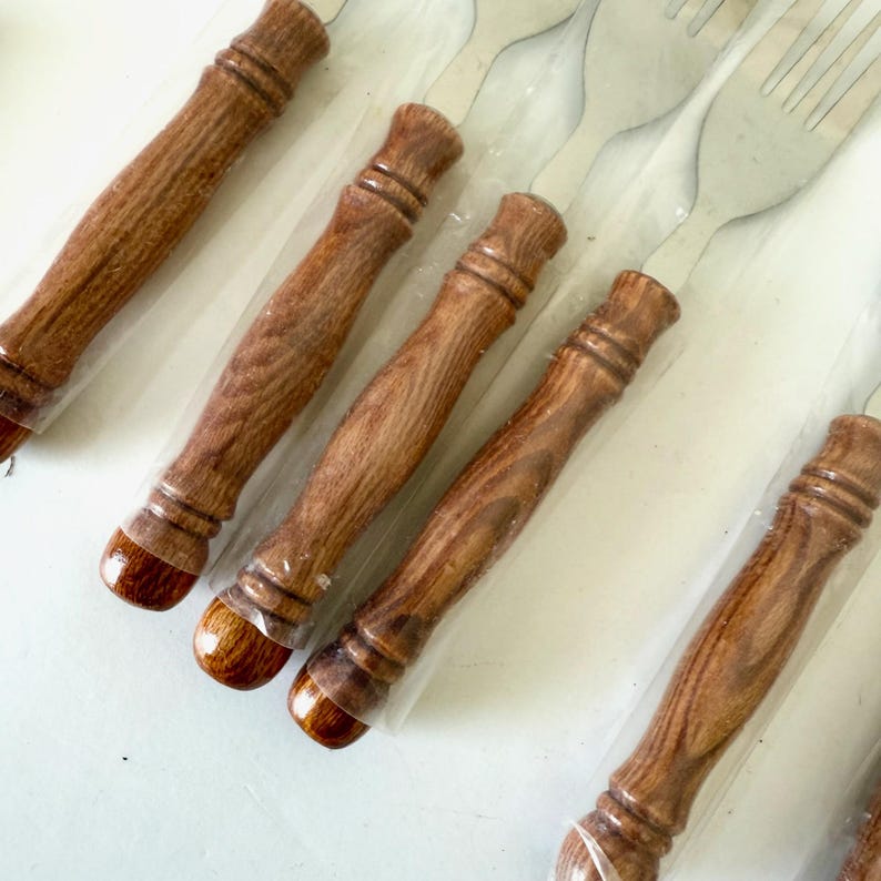 K&ouml;nnte beinhalten: Ein Set Gabeln mit Edelstahlzinken und Holzgriffen. Die Griffe sind in einem warmen Braunton gehalten und haben eine gl&auml;nzende Oberfl&auml;che. Die Gabeln sind einzeln in Klarsichtfolie verpackt.