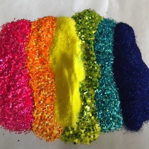 Puede incluir: Una vibrante exhibici&oacute;n de purpurina colorida en un arreglo de arco&iacute;ris. Los colores incluyen rosa, naranja, amarillo, verde, turquesa y azul. La purpurina se extiende en montones separados, creando una presentaci&oacute;n visualmente atractiva y festiva.