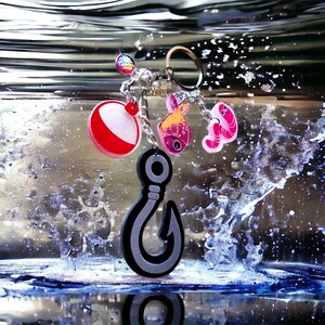 May include: A silver charm bracelet with a variety of charms, including a red and white fishing bobber, a pink fish, a pink and white seashell, and a silver hook. The charms are hanging from a silver chain.