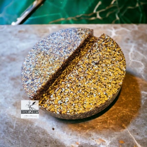 May include: A round, brown and gold glitter bottle stopper with a split design. The stopper is made of resin and has a speckled appearance.