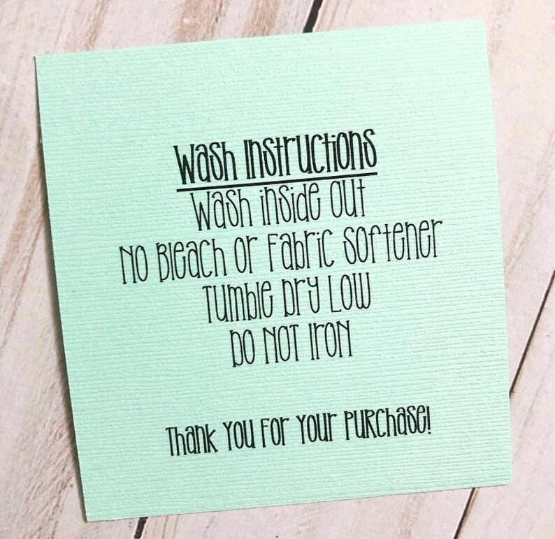 May include: A pale green card with black text detailing wash instructions, including "Wash inside out" and "Do not iron". The card also includes the text "Thank You For Your Purchase!"