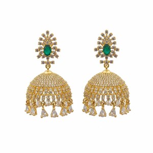 Op de afbeelding: Een paar goudkleurige jhumka-oorbellen met een klokvormige koepel bedekt met heldere pavé-kristallen. Elke oorbel heeft een centrale ovaal geslepen groene steen in het bovenstuk, met bungelende druppelvormige kristallen langs de onderrand.