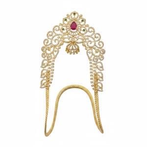 May include: A gold-toned headpiece with intricate filigree and sparkling clear and green gemstones. A large, teardrop-shaped red gemstone is centered at the top. The piece has a curved, open design with a textured band.