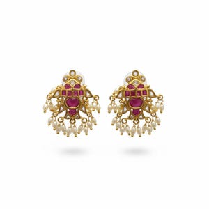 May include: A pair of gold-toned earrings with a central oval ruby surrounded by smaller rubies and clear stones. The earrings feature a floral design with dangling white pearls, creating an elegant and ornate look.