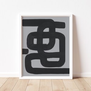 Puede incluir: Impresión de arte abstracto con líneas y formas negras sobre un fondo gris. La impresión está enmarcada en un marco blanco.