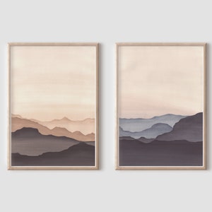 May include: Two framed watercolor prints depicting layered mountain ranges in shades of brown and blue. The artwork features a minimalist landscape with a soft, neutral color palette, perfect for home decor.