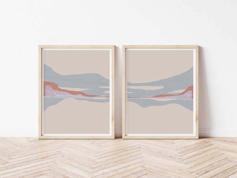 Puede incluir: Dos impresiones abstractas de paisajes enmarcadas con un fondo beige y formas abstractas azules, rosas y marrones.