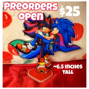 May include: A clear acrylic standee featuring two cartoon characters embracing. The characters are blue and black with red accents. The standee is approximately 6.5 inches tall and has the text "PREORDERS OPEN".