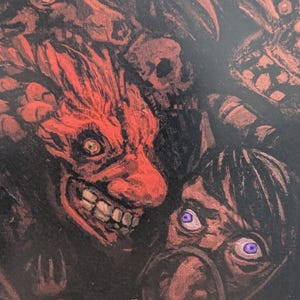 May include: A dark, detailed illustration featuring a red, demonic face with a wide grin and sharp teeth. Other faces and skulls are partially visible in the background, with purple eyes and a dark color palette.