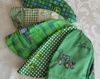 May include: Four green and yellow John Deere themed fabric hats. The hats are made of different fabrics with plaid, checkered, and solid green patterns. The hats have a John Deere logo and tractor designs.