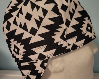 May include: Black and white geometric patterned welding cap with ear flaps.