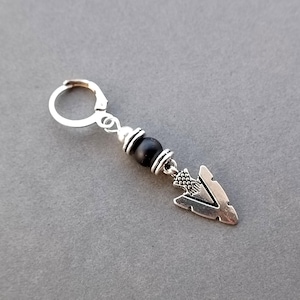 May include: Silver earring with a black bead and an arrowhead charm.