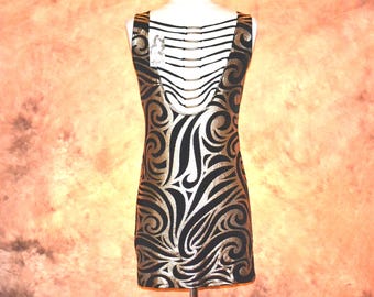 May include: A sleeveless dress featuring a black and metallic gold swirling pattern. The back of the garment has a deep scoop neckline with multiple thin horizontal black straps connected by small gold-toned metal rings. A white clothing tag is attached.