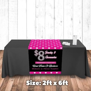May include: A black table with a black tablecloth. A pink and white patterned table runner displays the text "$8 Jewelry & Accessories" and "Independent Consultant". The table runner is 2 feet by 6 feet.