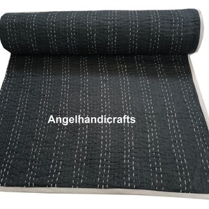 May include: A black kantha quilt with white stitching in a vertical pattern. The quilt is rolled up and the text "Angelhandicrafts" is visible in the center.