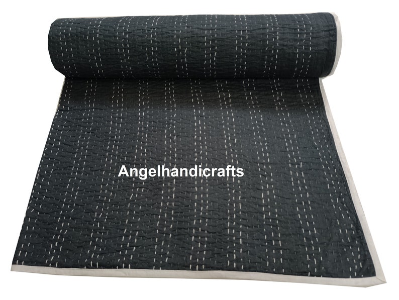 May include: A black kantha quilt with white stitching in a vertical pattern. The quilt is rolled up and the text "Angelhandicrafts" is visible in the center.