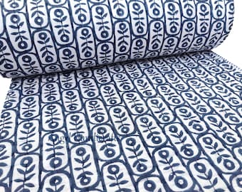 Puede incluir: Un edredón enrollado, blanco y azul marino con un patrón floral repetido. El diseño presenta flores estilizadas dentro de marcos rectangulares. El edredón está hecho de una tela suave y acolchada, ideal para ropa de cama o decoración del hogar.