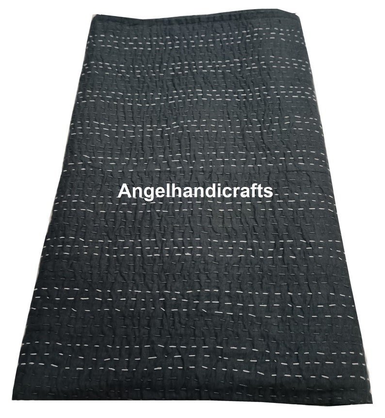 May include: A black kantha quilt with white stitching. The quilt is made of cotton and is hand-stitched. The quilt is folded in half and is lying flat on a white surface. The text "Angelhandicrafts" is visible in the center of the quilt.