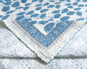 May include: A white and blue patterned quilt with a floral border. The quilt features a repeating pattern of blue leaf shapes on a white background. The border has a floral design in blue and white.