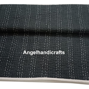 May include: Black kantha quilt with white stitching. The quilt is folded in half and has a white border. The text "Angelhandicrafts" is visible in the center of the quilt.