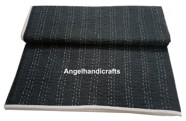 May include: Black kantha quilt with white stitching. The quilt is folded in half and has a white border. The text "Angelhandicrafts" is visible in the center of the quilt.