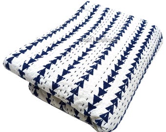 May include: White and navy blue quilt featuring a repeating triangle design. The quilt is folded, displaying the pattern and stitching. The text "Angel Handicrafts" is visible on the quilt.