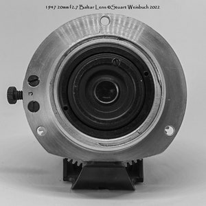 Puede incluir: Un objetivo de c&aacute;mara negro y plateado con una apertura de 20 mm f2.7. El objetivo est&aacute; etiquetado como "1947 20mm f2.7 Baltlar Lens &copy;Stuart Weisbuch 2022".