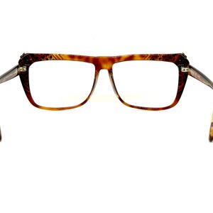 May include: A pair of brown tortoise shell eyeglasses with a square frame.